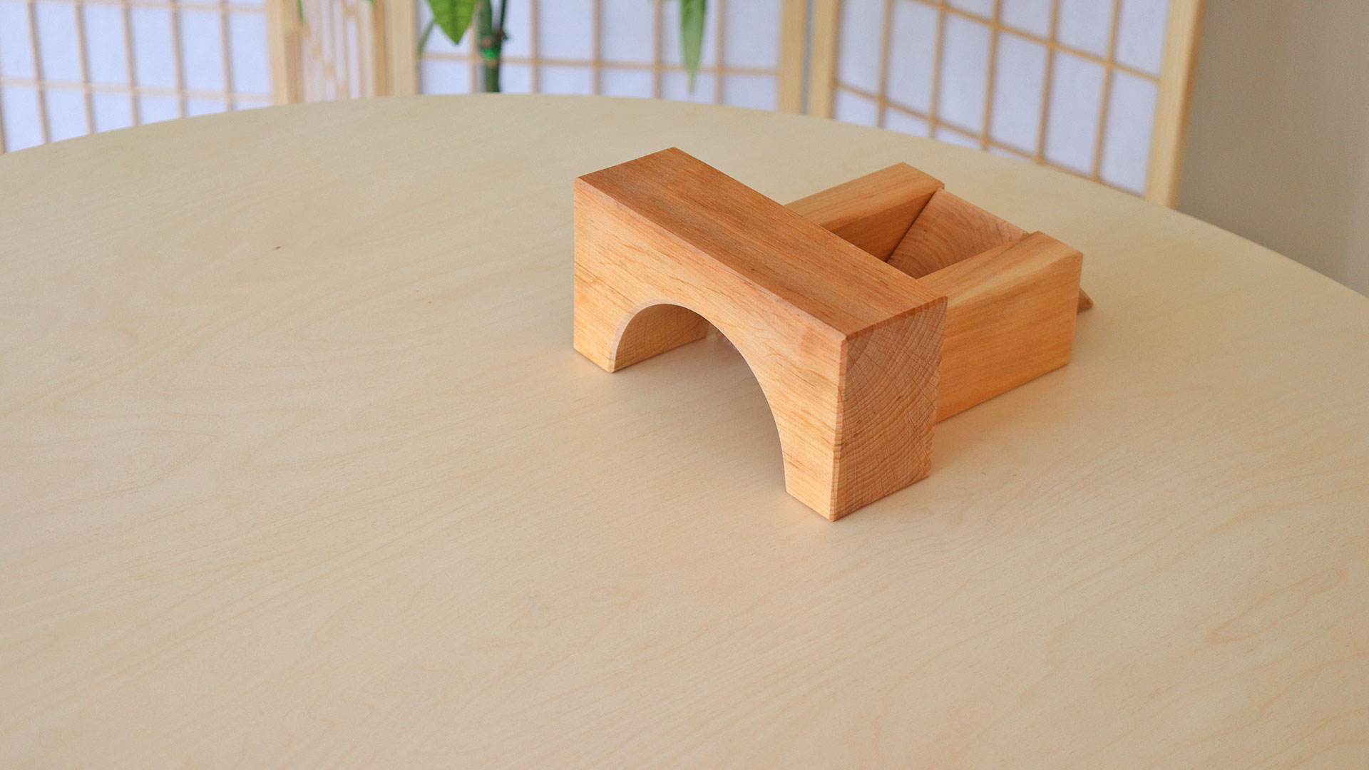 Aufbau mit großen Holzbauklötzen auf einem Tisch.