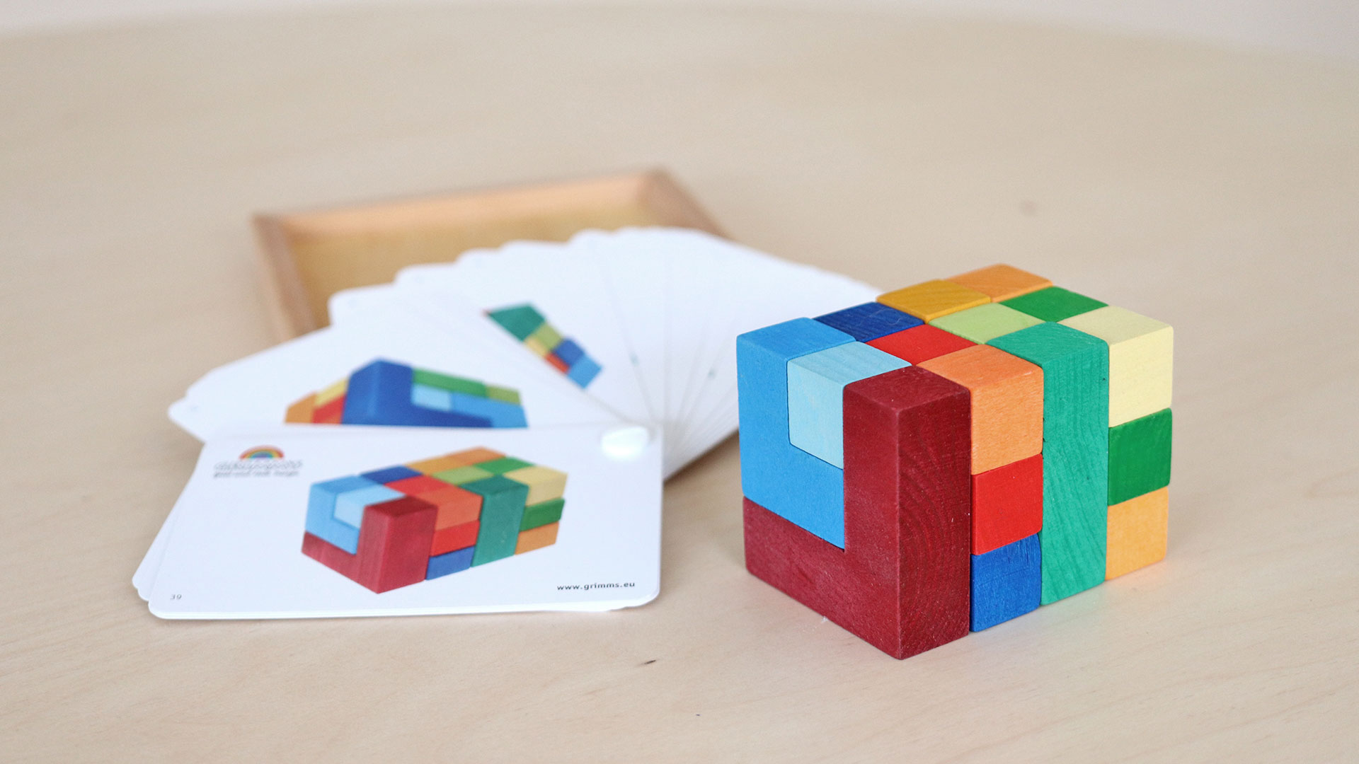 3D wooden block assembled from several colourful wooden bricks.
