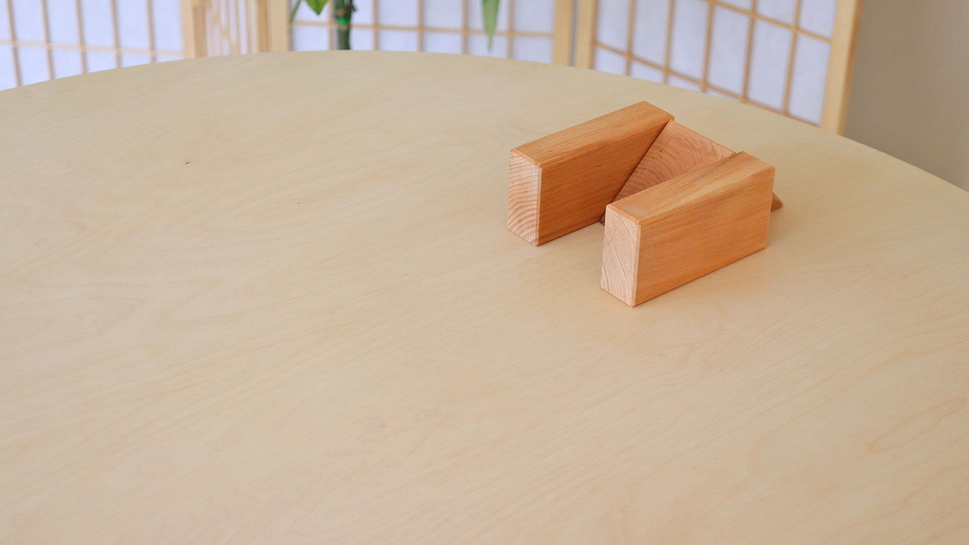 Aufbau mit großen Holzbauklötzen auf einem Tisch.