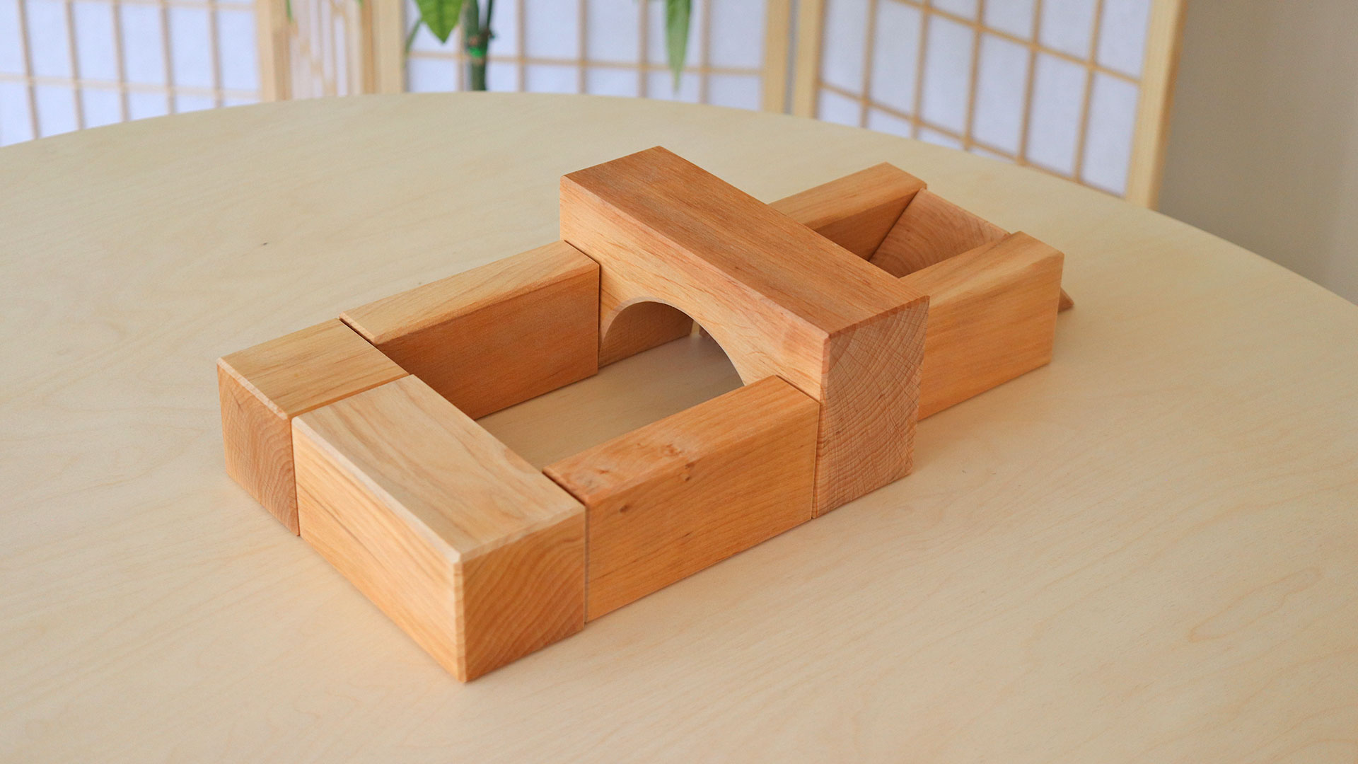 Setting up with large wooden building blocks on a table.