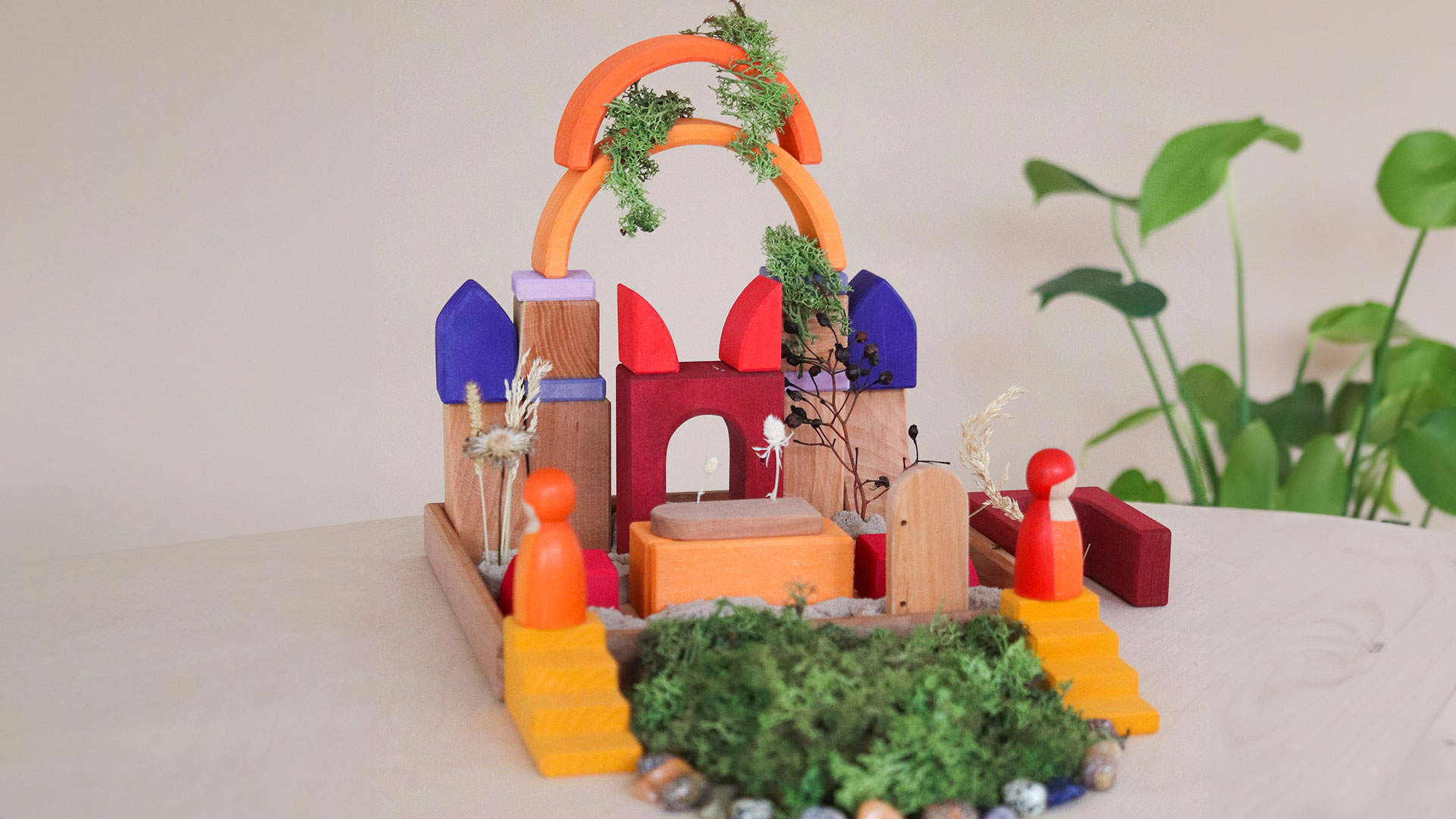 Wooden blocks and natural materials are arranged as a play landscape.